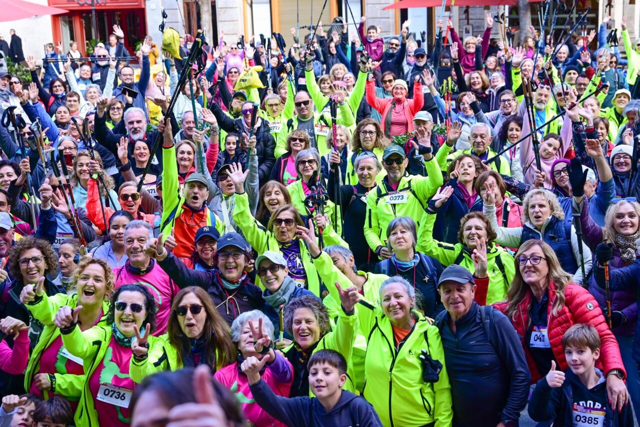 Participantes de la marcha solidaria levantando las manos con entusiasmo.