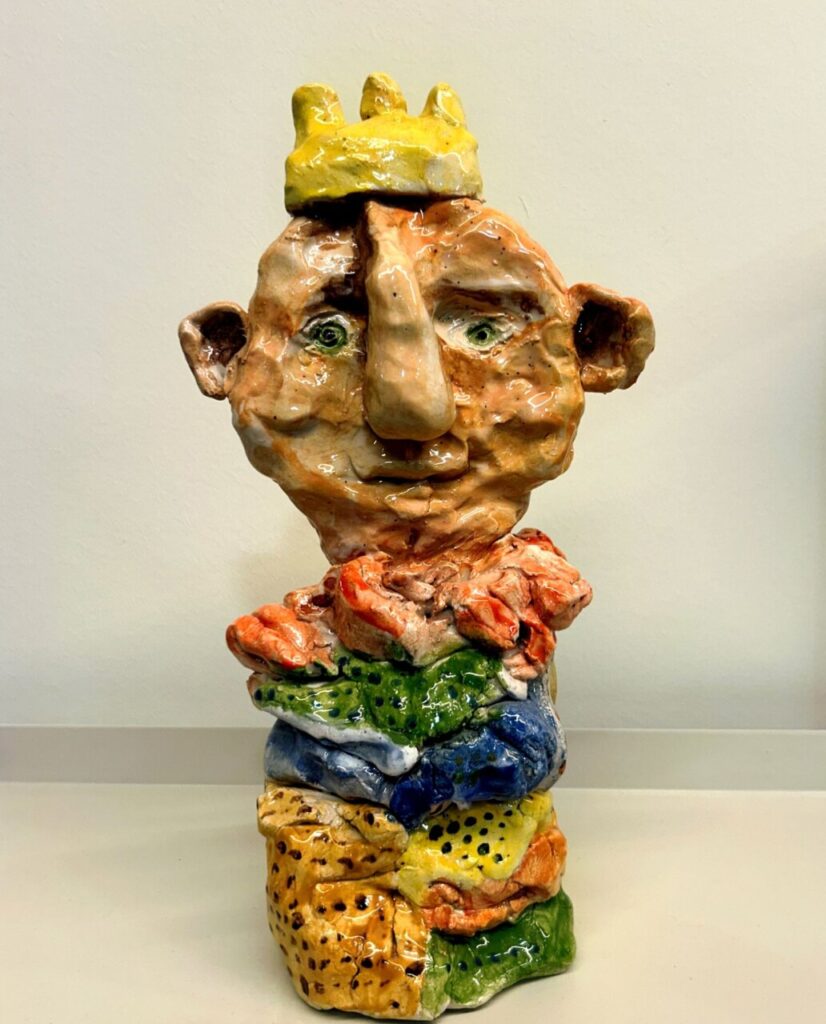 Escultura cerámica de Martín Garrido con colores vibrantes y una corona amarilla