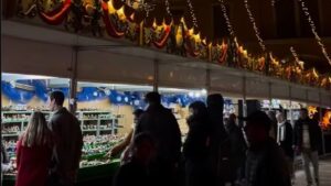 Personas visitando un mercado navide&ntilde;o iluminado en Mallorca
