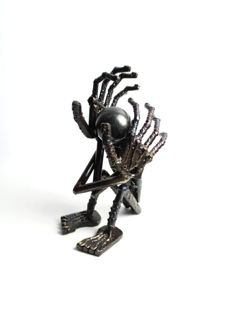 Escultura de Toni Coll con múltiples manos y una esfera negra