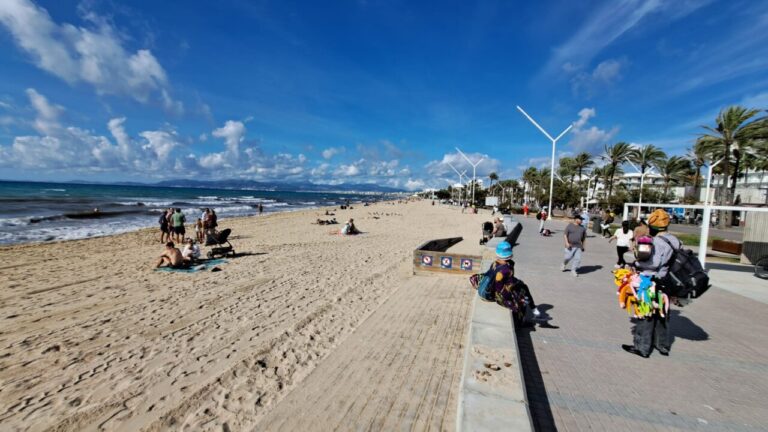Vista de la Playa de Palma con personas disfrutando del sol y la arena.