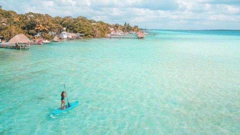Persona practicando paddle surf en aguas turquesas de Playa del Carmen
