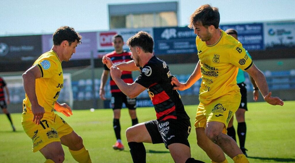 Jugadores del Poblense compiten en un partido contra el Reus
