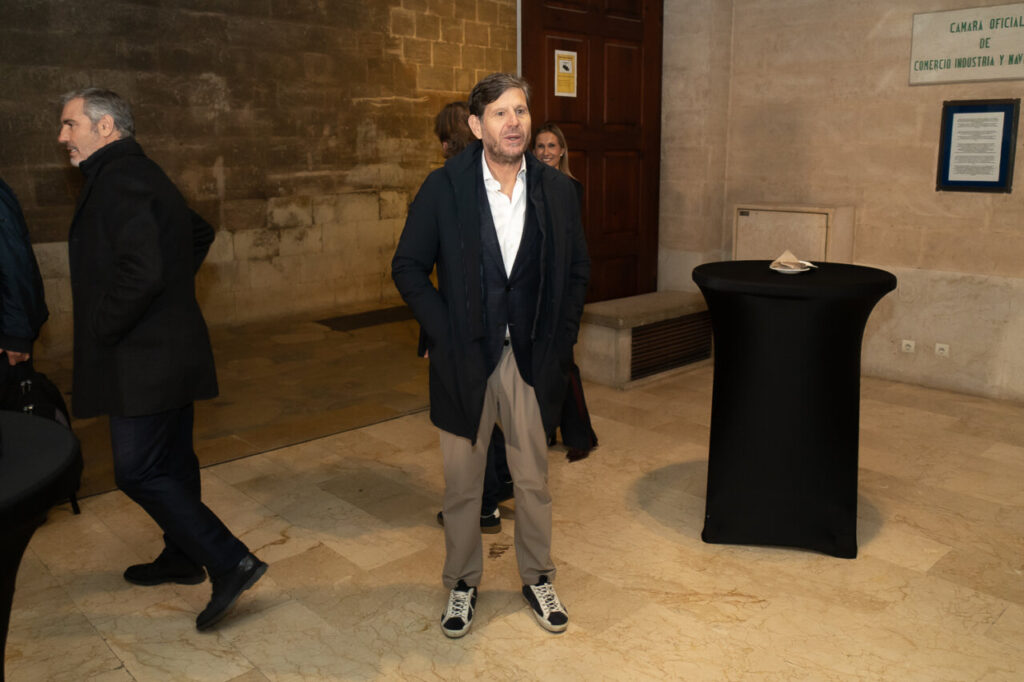 Hombre en un evento de premiaci&oacute;n en Mallorca con fondo de piedra.