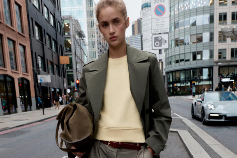 Modelo con abrigo y suéter en una calle urbana