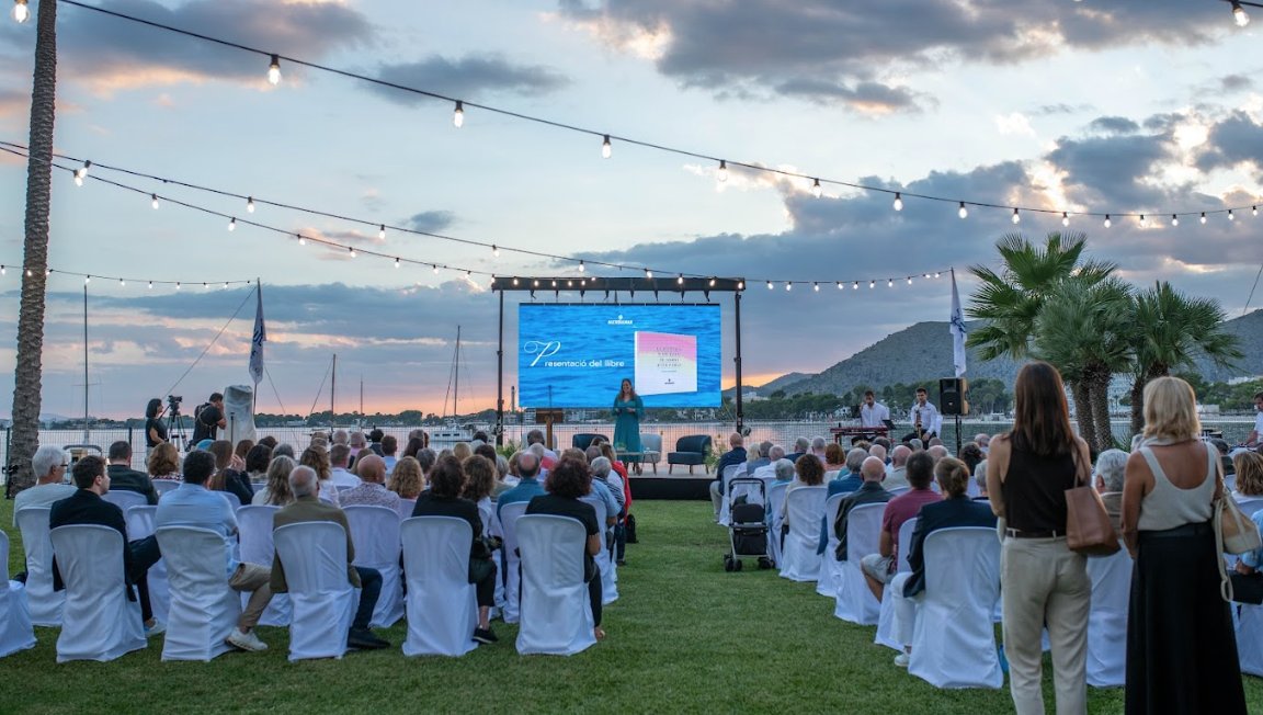 Presentación del libro sobre la historia del puerto de Alcudia en un evento al aire libre.