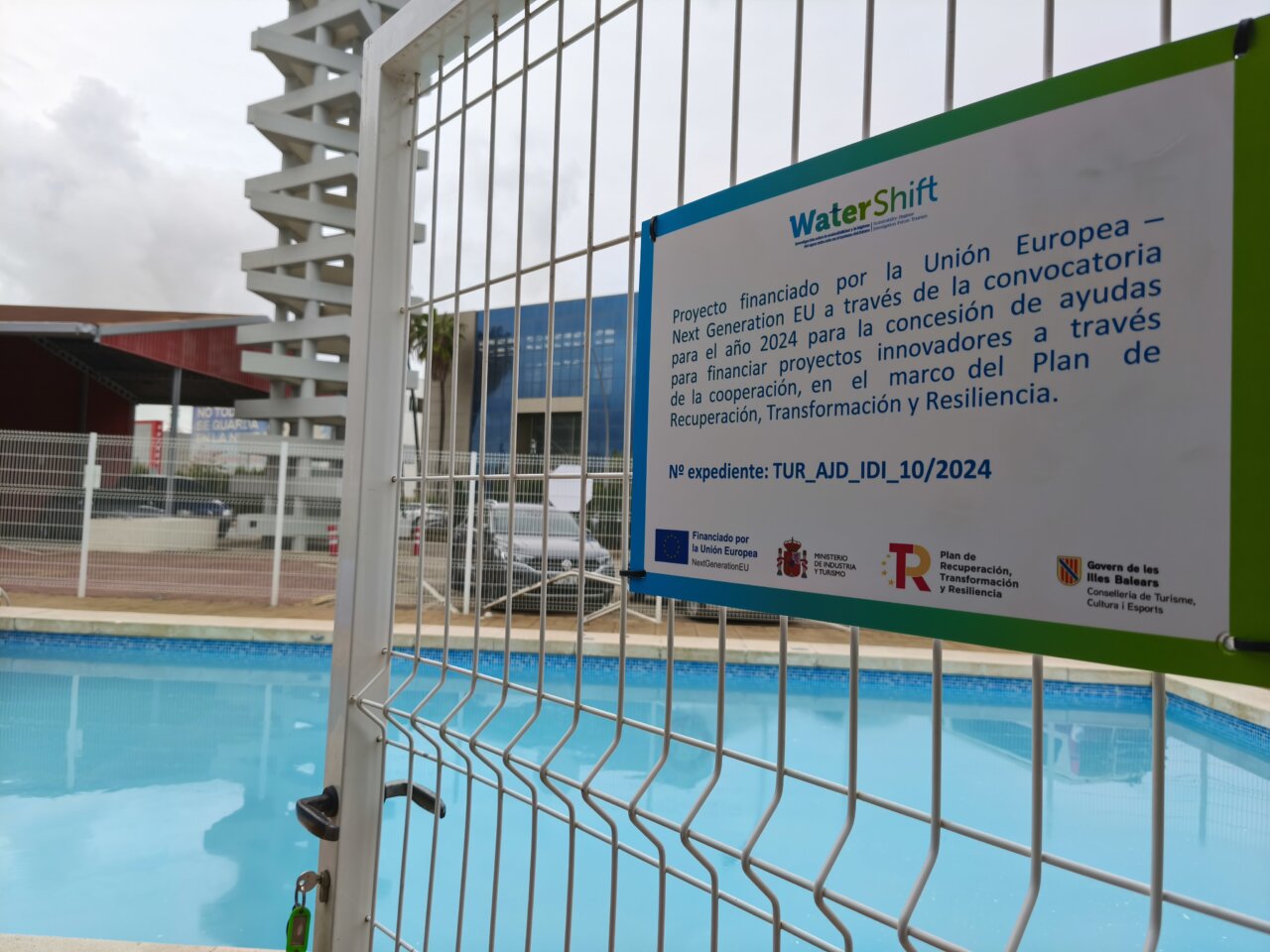 Cartel informativo sobre el proyecto WaterShift junto a una piscina