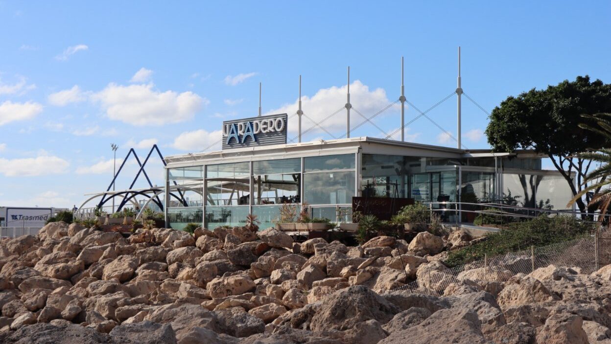 Vista del restaurante Varadero en el puerto de Palma con rocas y cielo azul