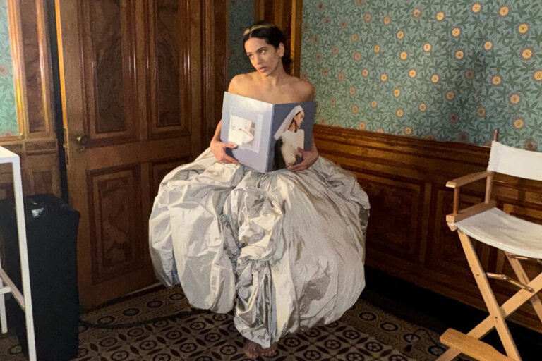 Rosalía sosteniendo un álbum en un vestido voluminoso