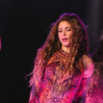 Shakira actuando en un escenario con bailarinas