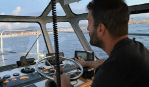 Práctico navegando en el puerto de Palma con timón en mano