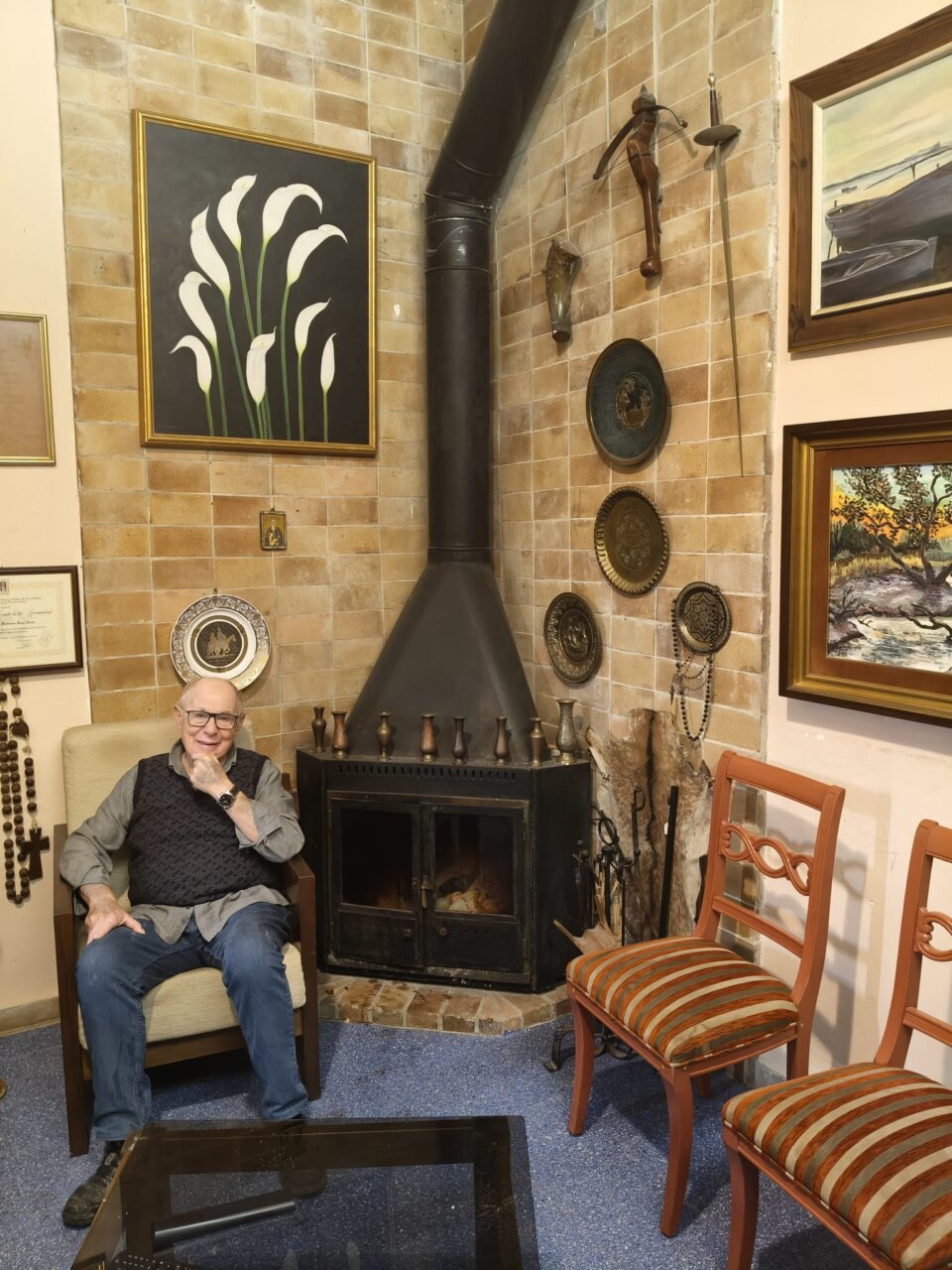 Tomeu Suau Serra sentado en un salón con decoración artística