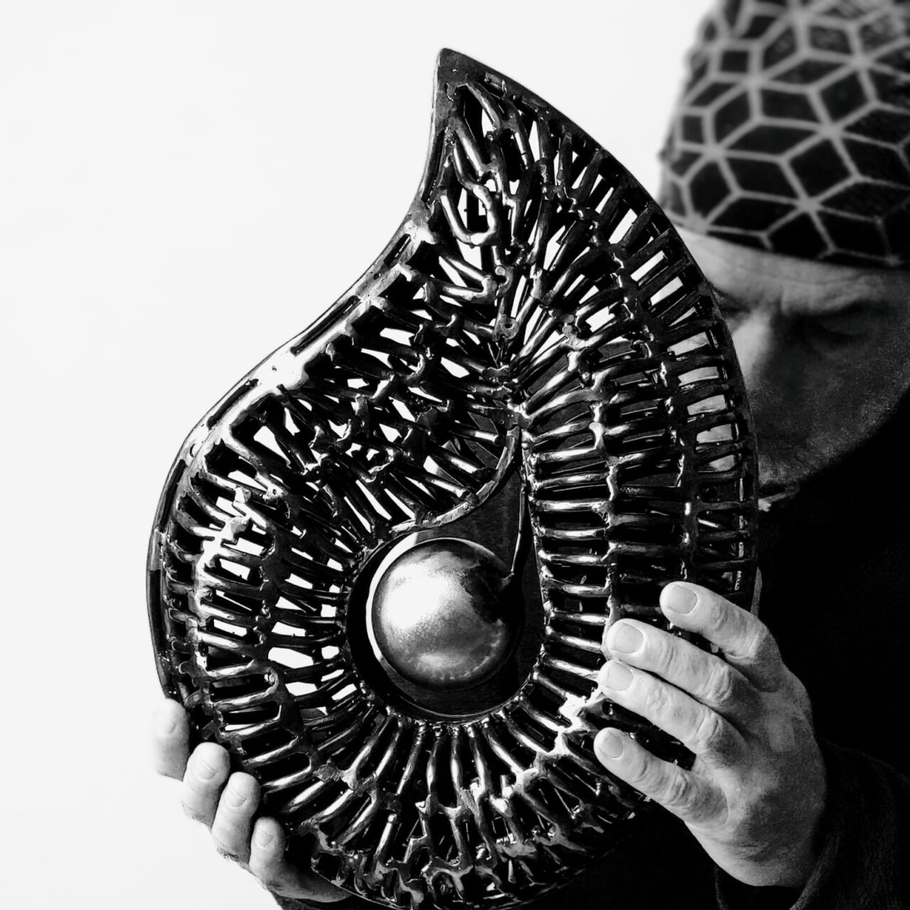 Toni Coll sosteniendo una escultura de metal en su taller