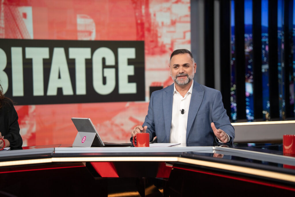 Presentador en el programa Torn de Paraula con fondo colorido.