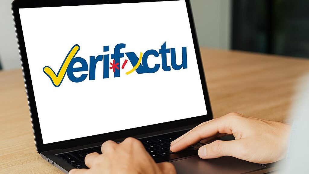 Persona usando un ordenador portátil con el logo de Verifactu en la pantalla.