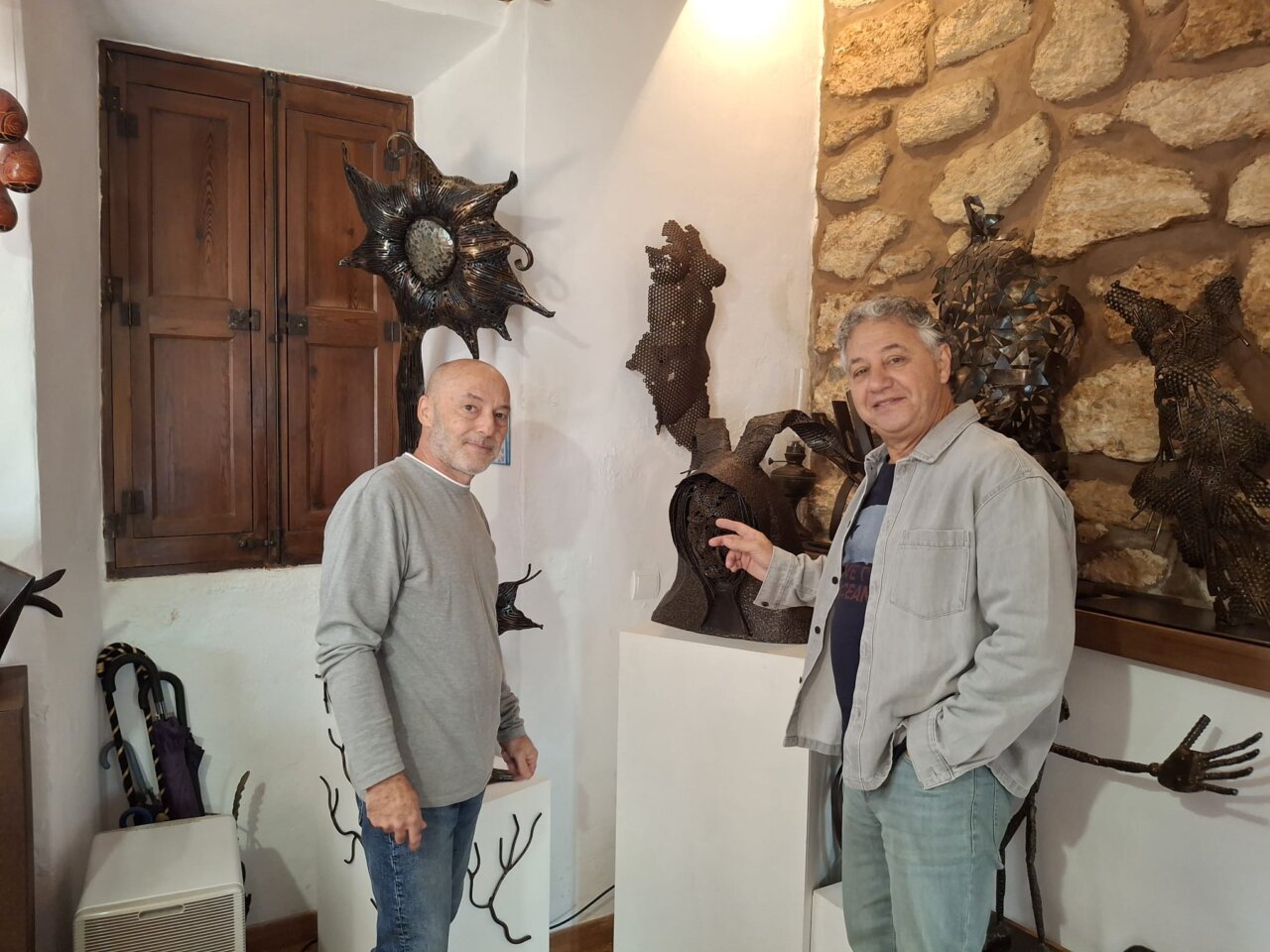 Xisco Barceló señalando una escultura de Toni Coll en su taller.