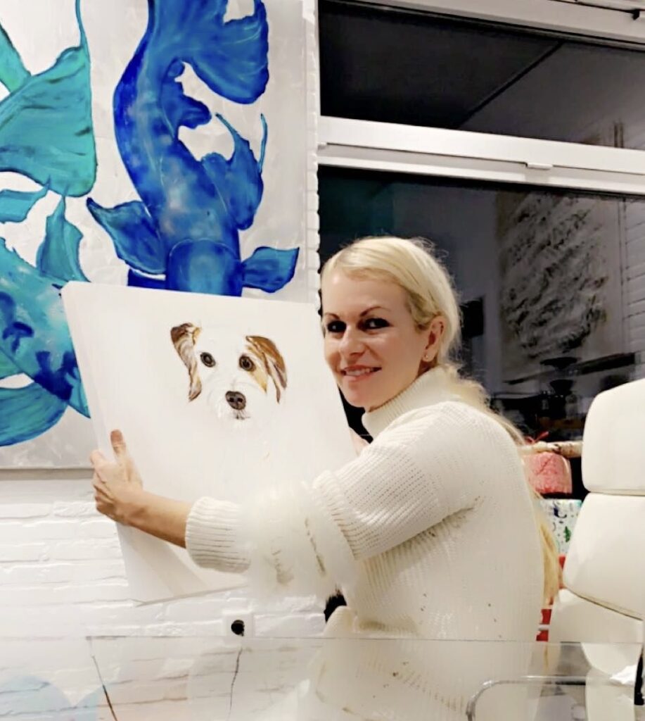 Yvonne Erdmann sosteniendo una pintura de un perro.