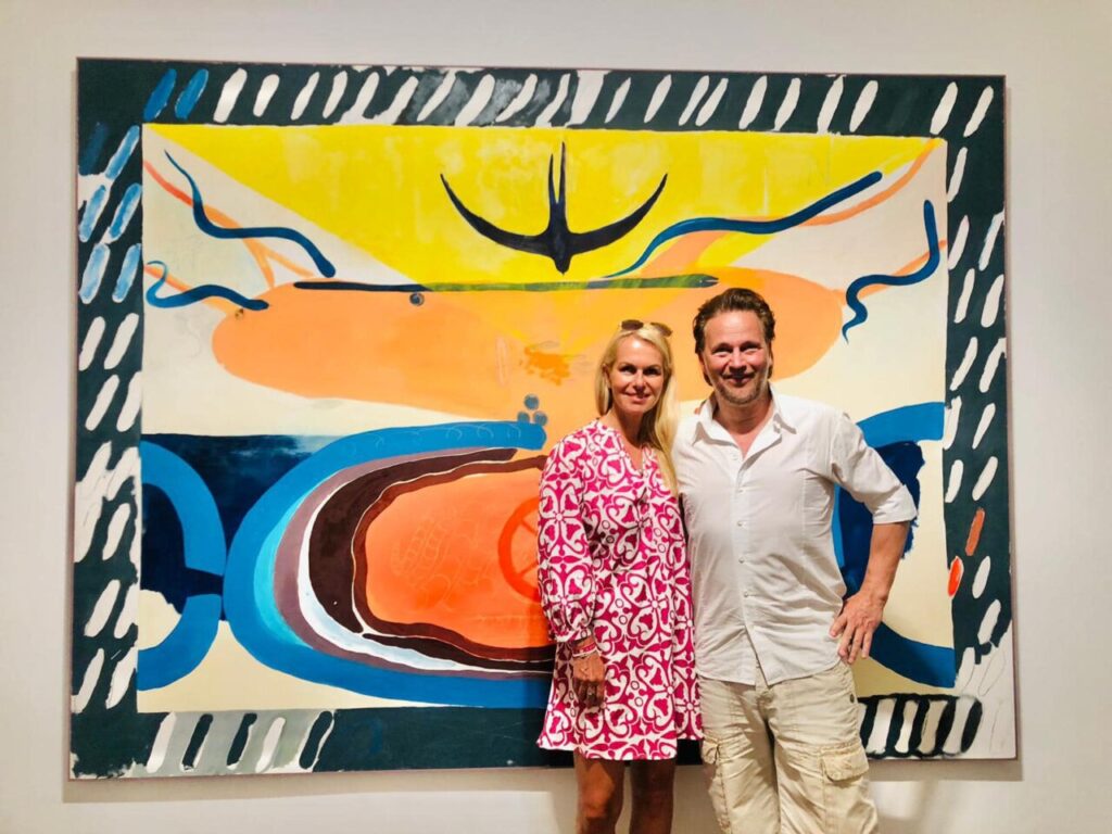 Yvonne Erdmann posando junto a su obra de arte colorida