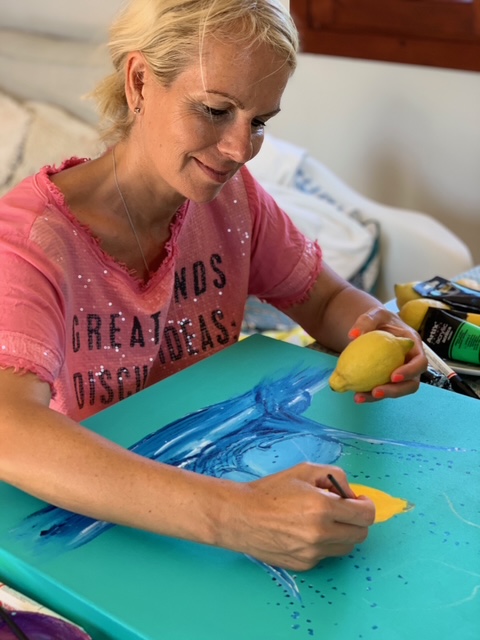 Yvonne Erdmann pintando un limón en un lienzo colorido