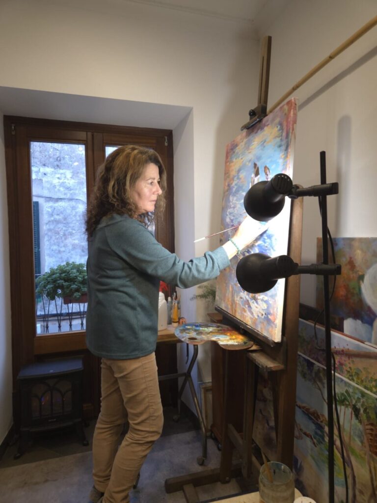 Dolors Mart&iacute; pintando en su taller con un caballete y paleta