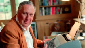 Frederick Forsyth sentado frente a una m&aacute;quina de escribir en su estudio