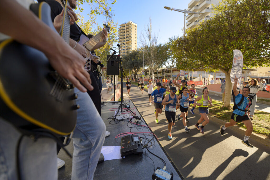 Corredores participando en la Half Marathon de Magaluf con música en vivo.