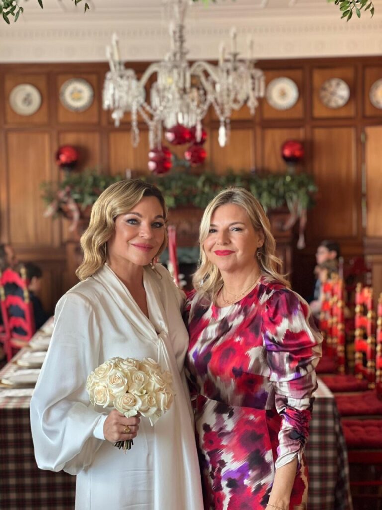 Mar&iacute;a Juan de Setmenat y amiga posando en la boda con flores blancas.