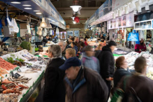Vista del Mercado del Olivar con muchas personas comprando mariscos y pescados frescos.