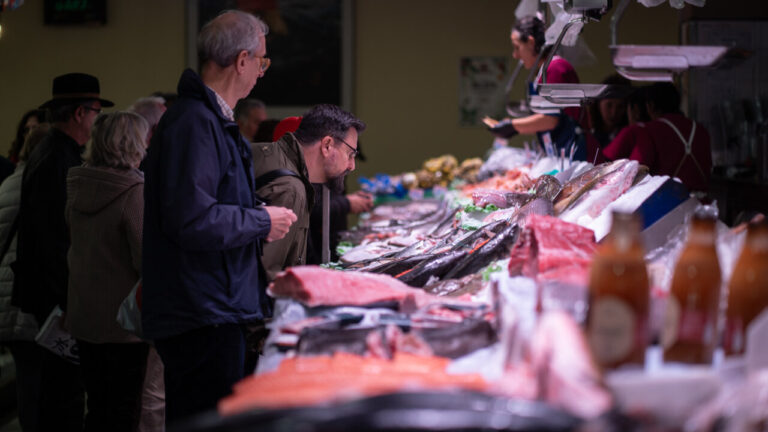 Visitantes observando la variedad de pescados en el mercado del Olivar