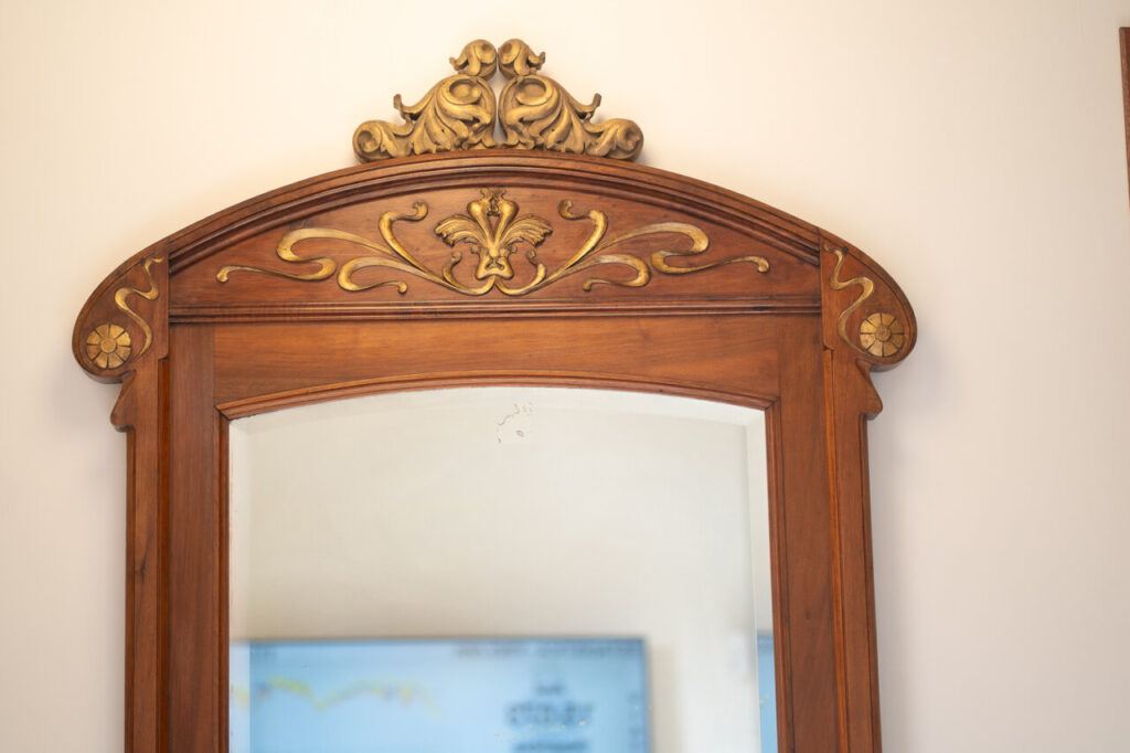Espejo antiguo con detalles dorados en la parte superior