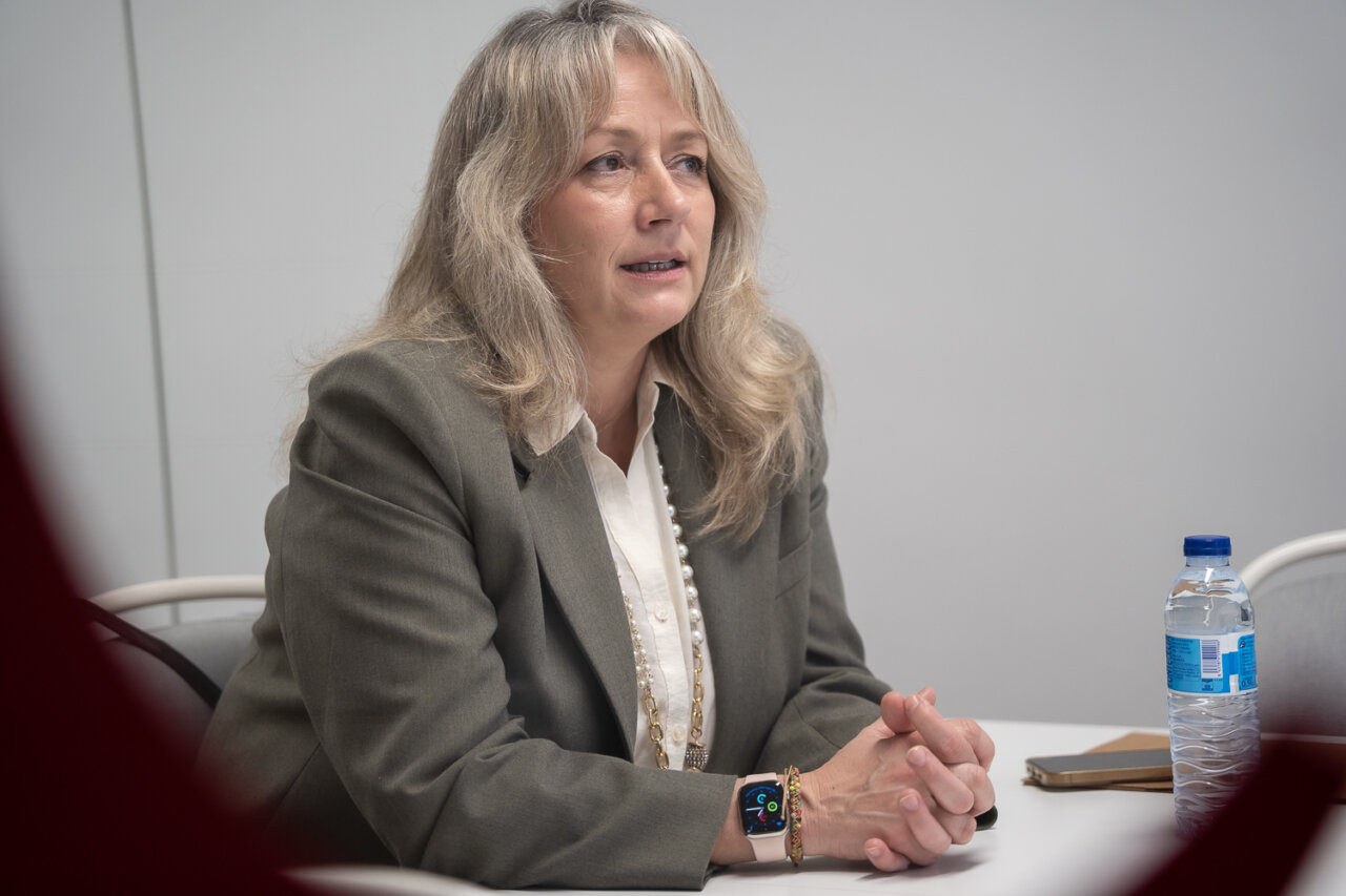 Mujer en reuni&oacute;n con cabello largo y suelto, vestida formalmente.