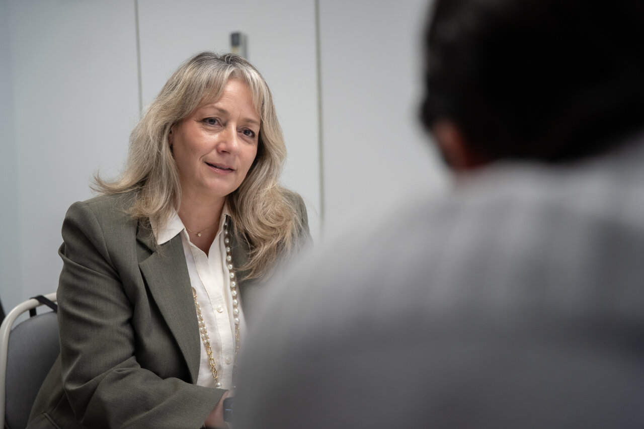 Mujer conversando en una reuni&oacute;n de trabajo con un enfoque profesional.