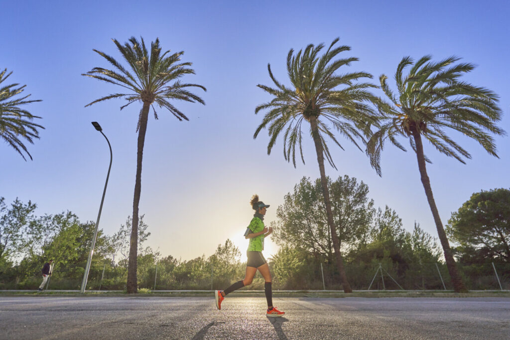 Corredora en Magaluf durante la Half Marathon 2026 con palmeras al fondo
