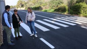 Tres personas observando la entrada asfaltada de Cala Figuera