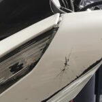 Motocicleta blanca con da&ntilde;os visibles en el lateral