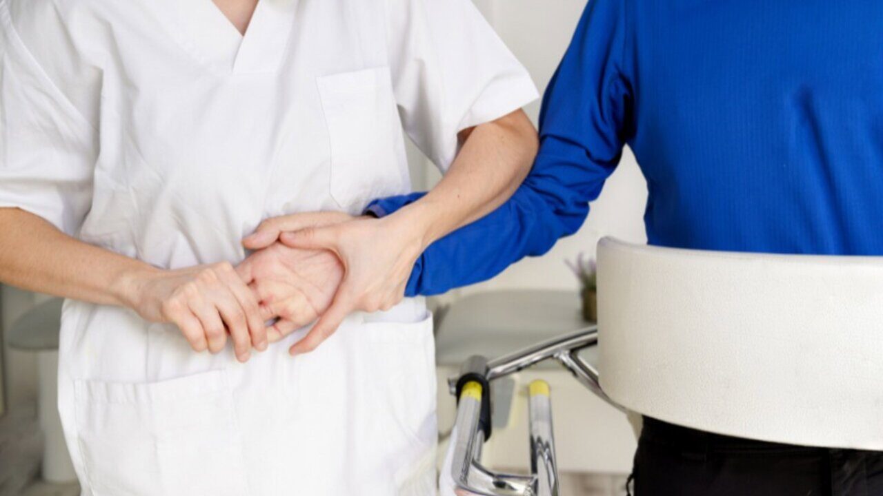 Profesional de la salud asistiendo a un paciente con ELA