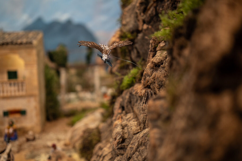 Diorama navideño con figura de ave en un belén