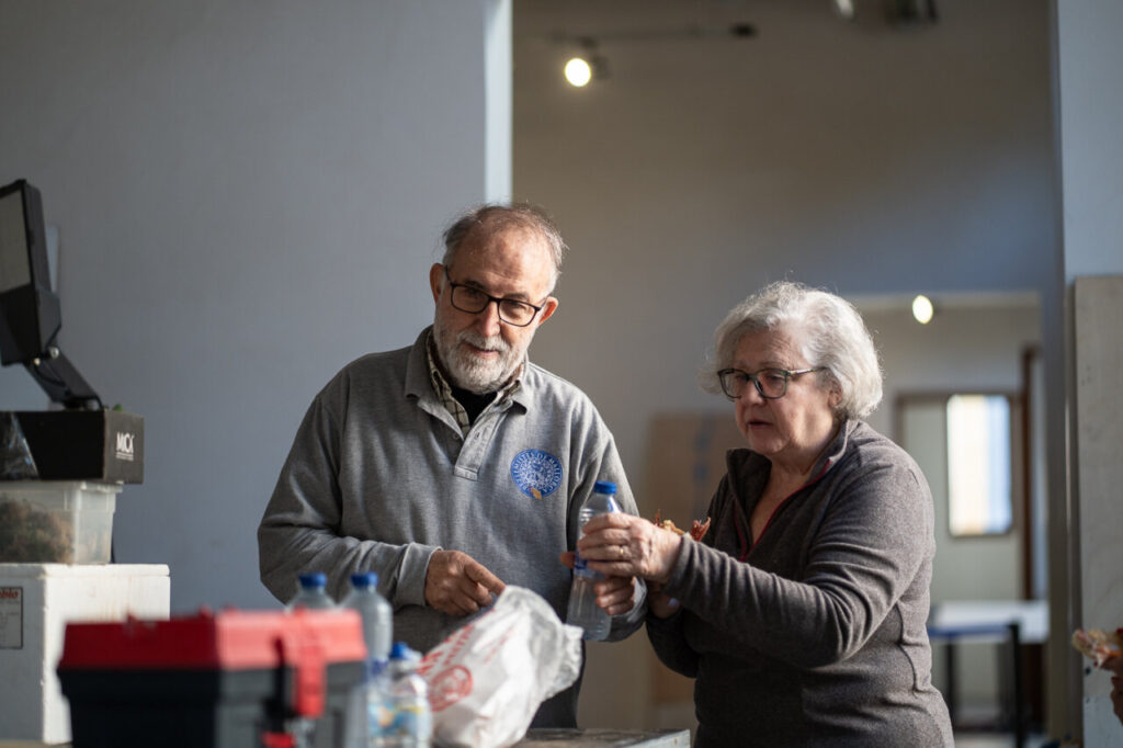 Dos personas trabajando en la creación de un belén navideño.