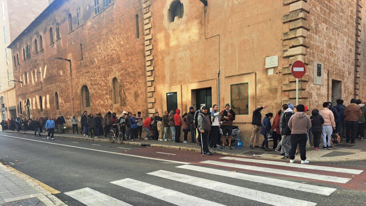 Colas de personas esperando para recibir men&uacute;s solidarios en Navidad