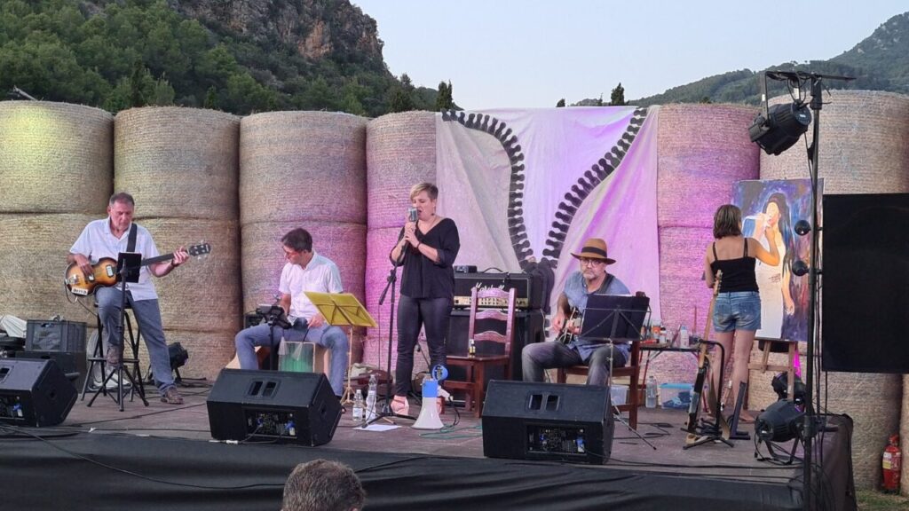 Concierto en vivo con m&uacute;sicos y una artista pintando.