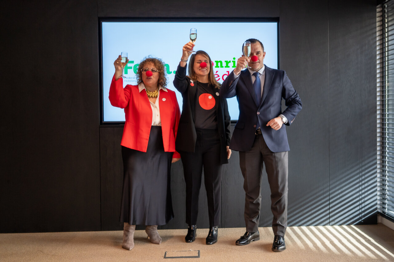 Tres personas levantando copas en un evento navide&ntilde;o