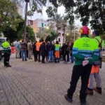 Grupo de personas en la plaza Llorenç Villalonga con vehículos de emergencia.