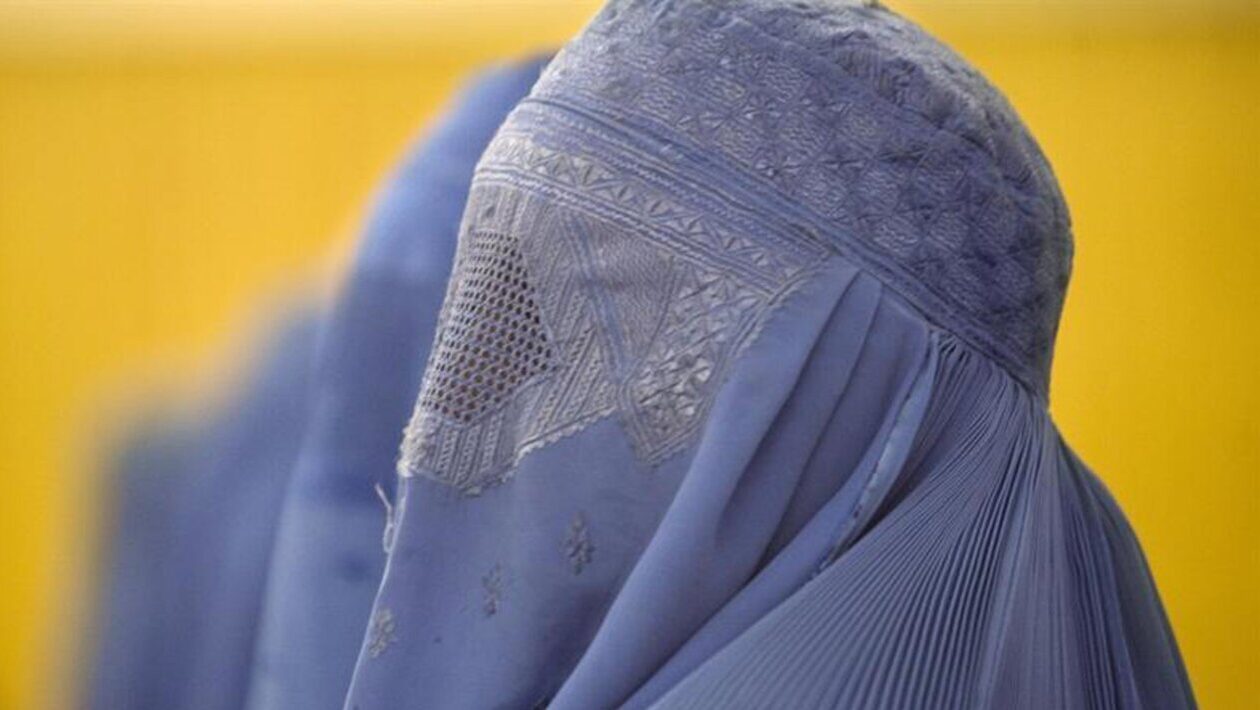 Mujer con burka azul en un entorno p&uacute;blico