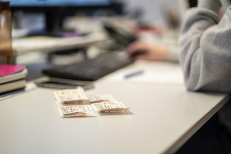 Décimos de lotería sobre una mesa con un teclado y una mano