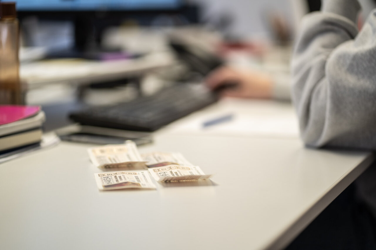D&eacute;cimos de loter&iacute;a sobre una mesa con un teclado y una mano