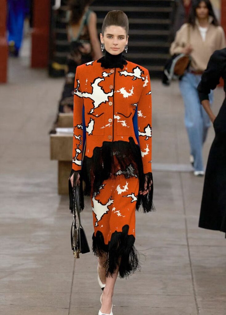 Modelo luciendo un conjunto de Chanel en un desfile de moda.