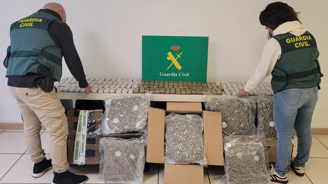 Agentes de la Guardia Civil inspeccionan paquetes con drogas en una mesa.