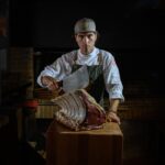 Chef sosteniendo un gran corte de carne en el restaurante Es Parc