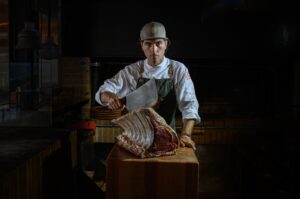 Chef sosteniendo un gran corte de carne en el restaurante Es Parc