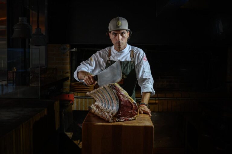 Chef sosteniendo un gran corte de carne en el restaurante Es Parc